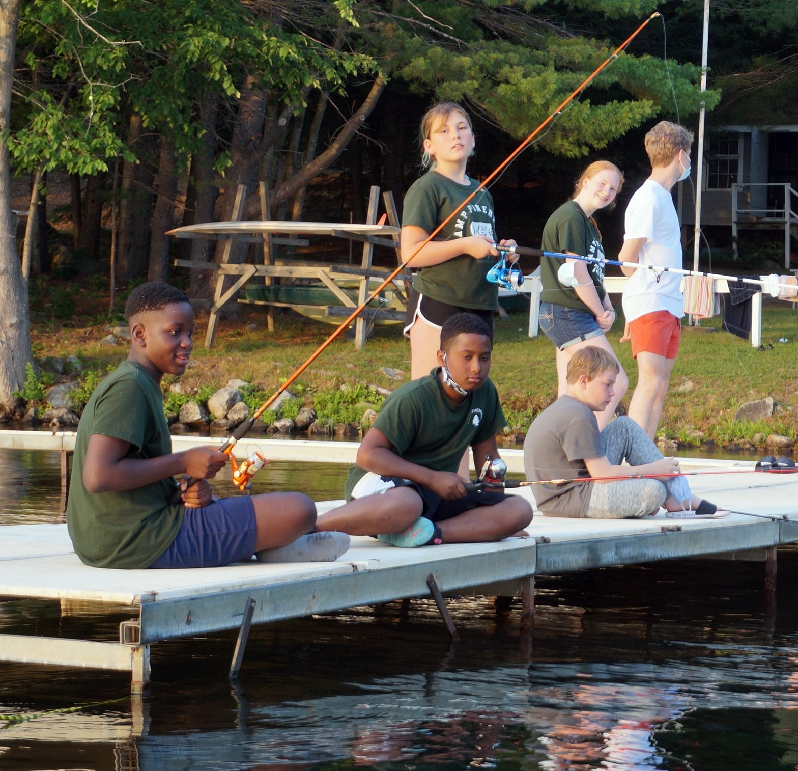 Kids fishing off dock at sunset