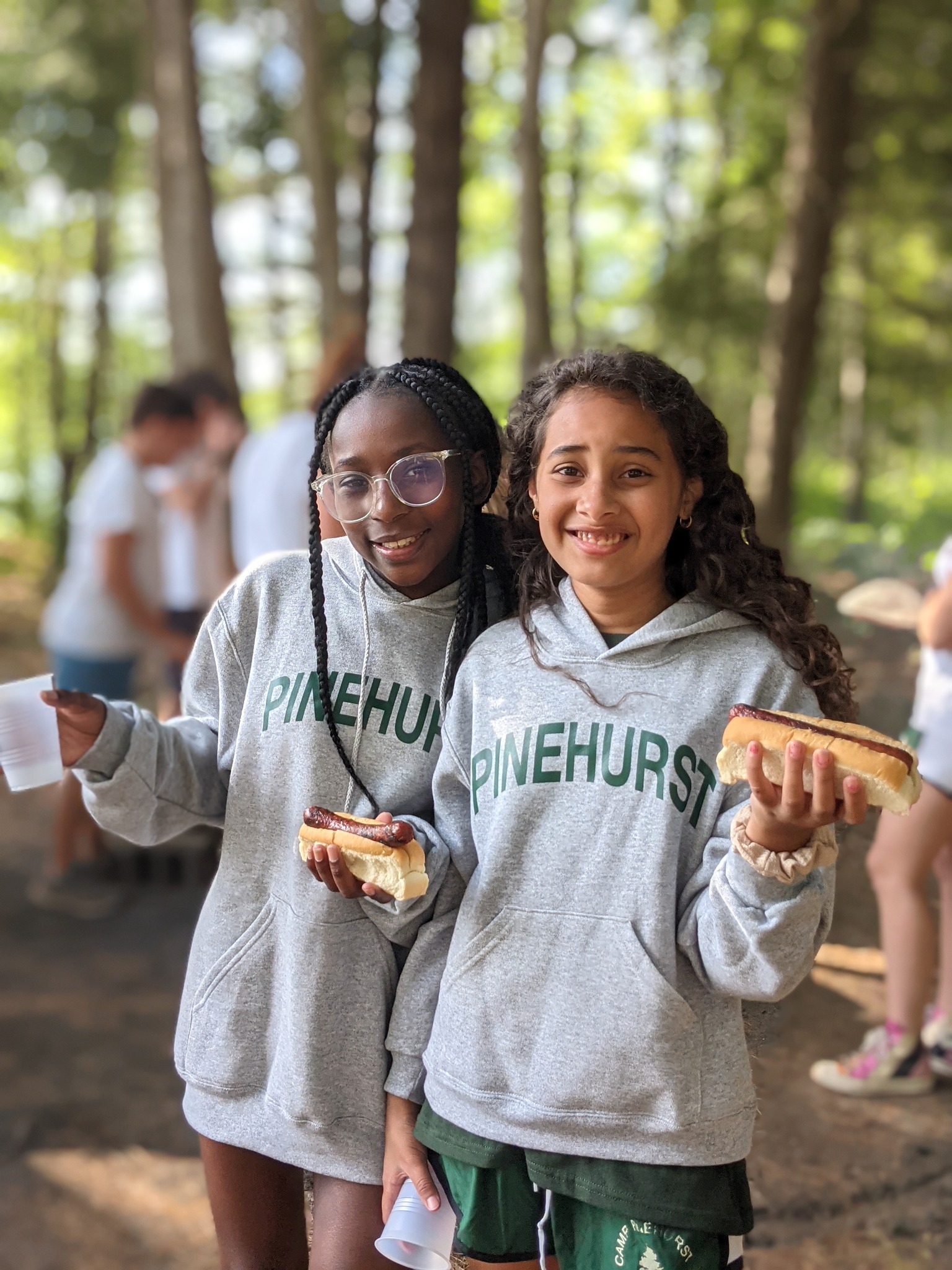 Two girls with hot dogs at cookout